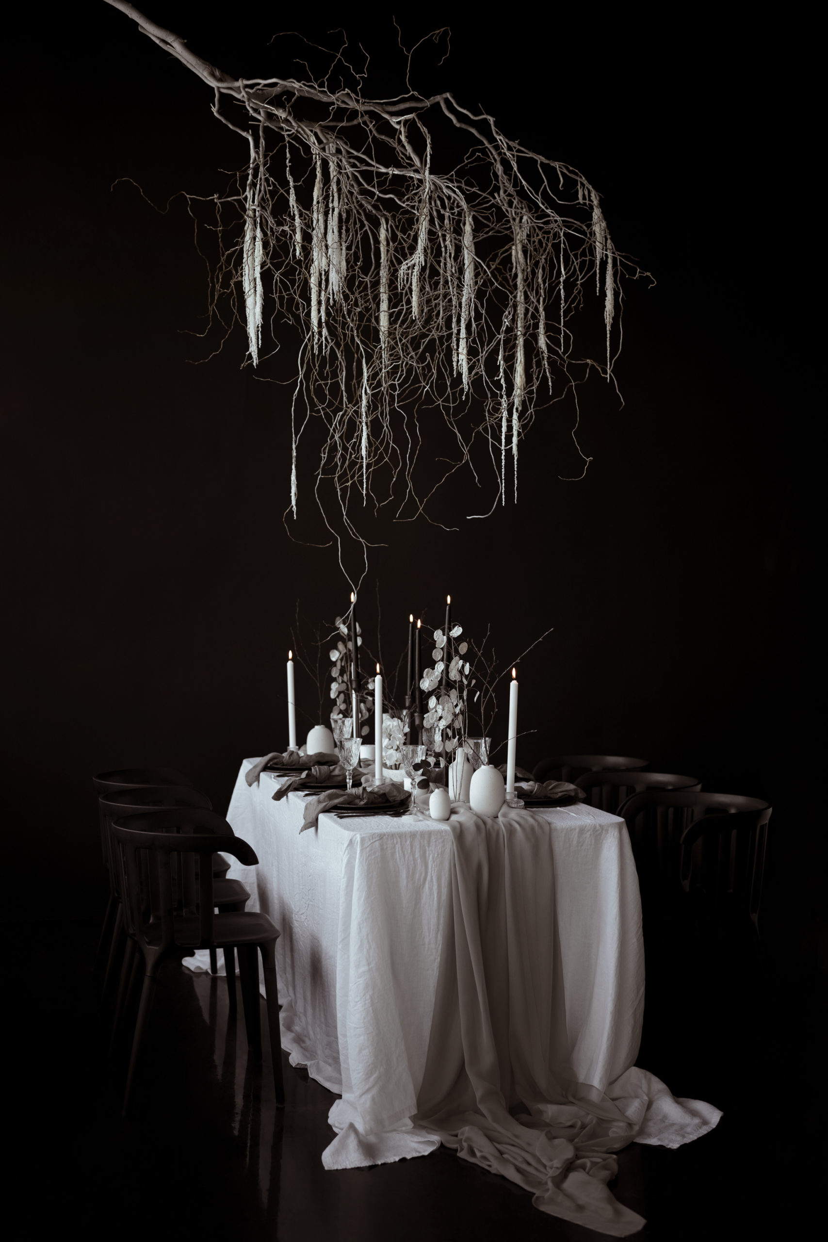 Black and white tablescape with handmade ceramics, candles and lunaria flowers.